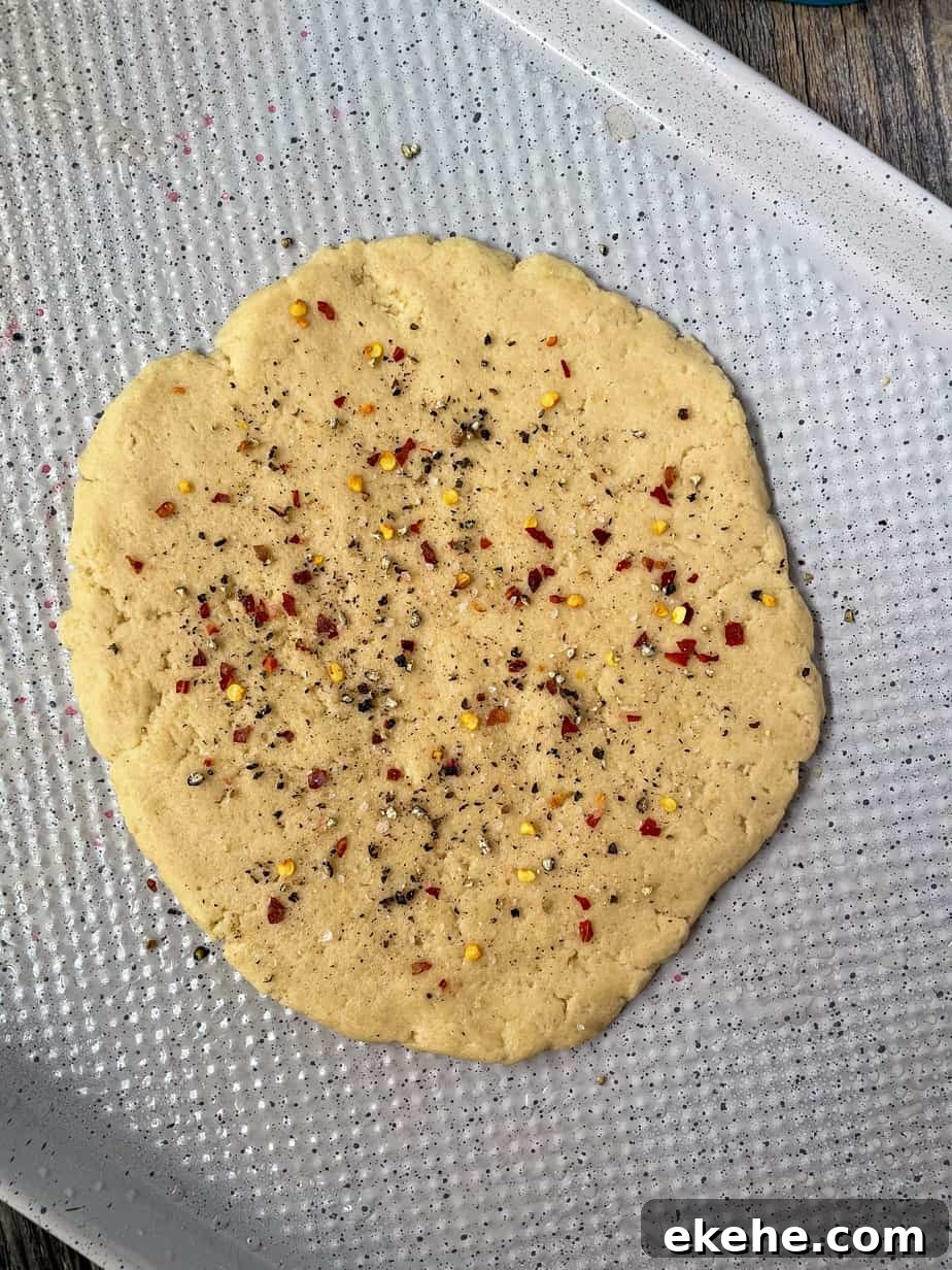 par baked flatbread crust on a white baking sheet