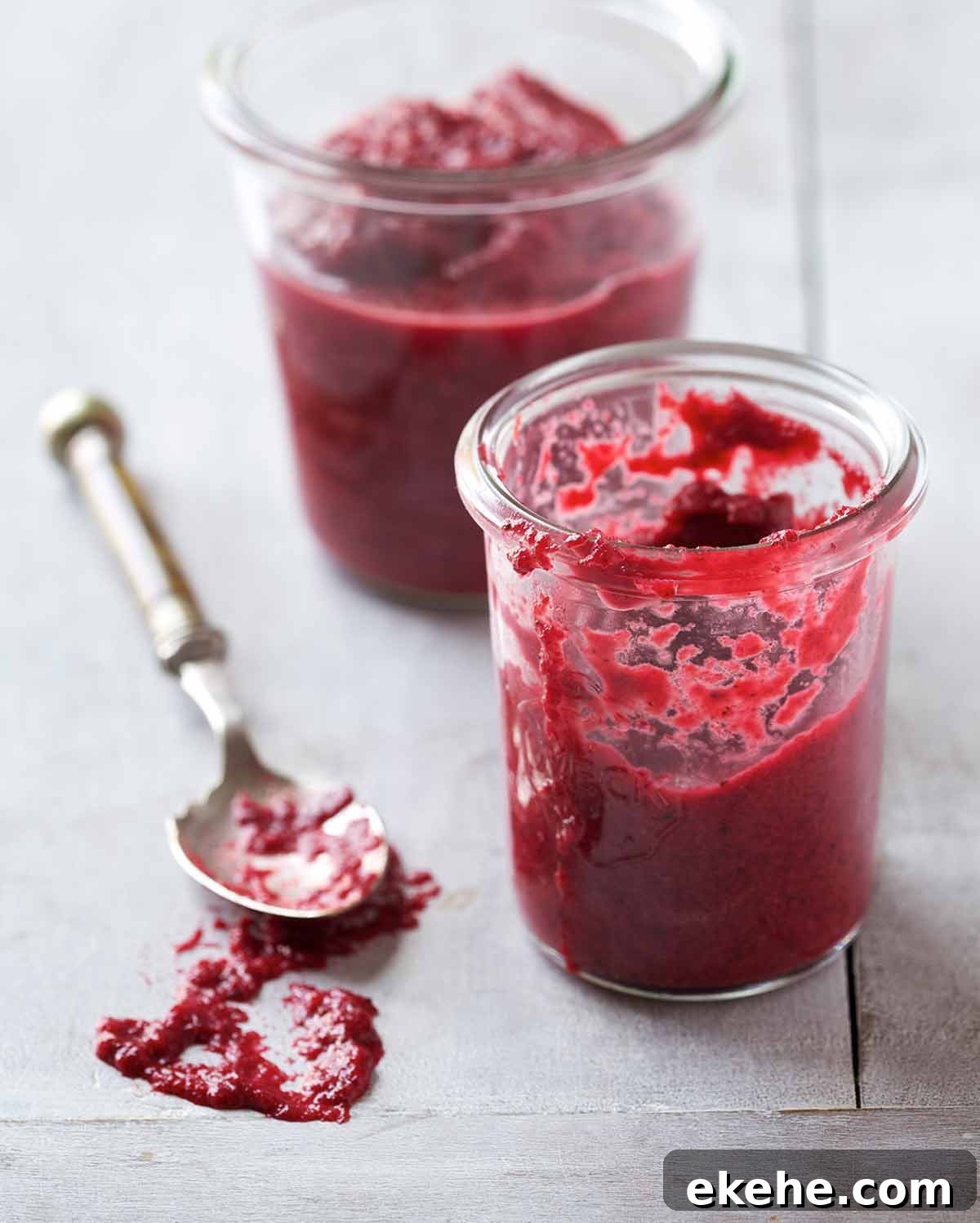 Two glass jars of homemade chrain with a silver spoon lying beside them.