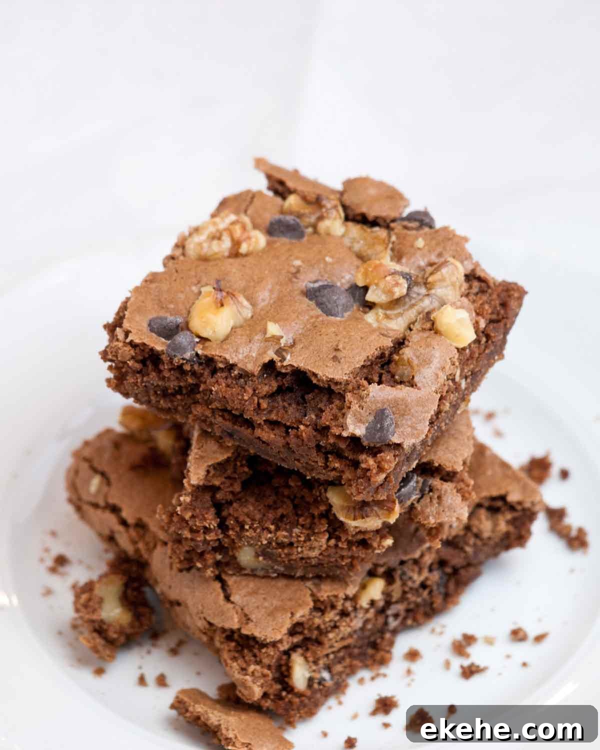 Three Passover brownies stacked on top of each other on a white plate.