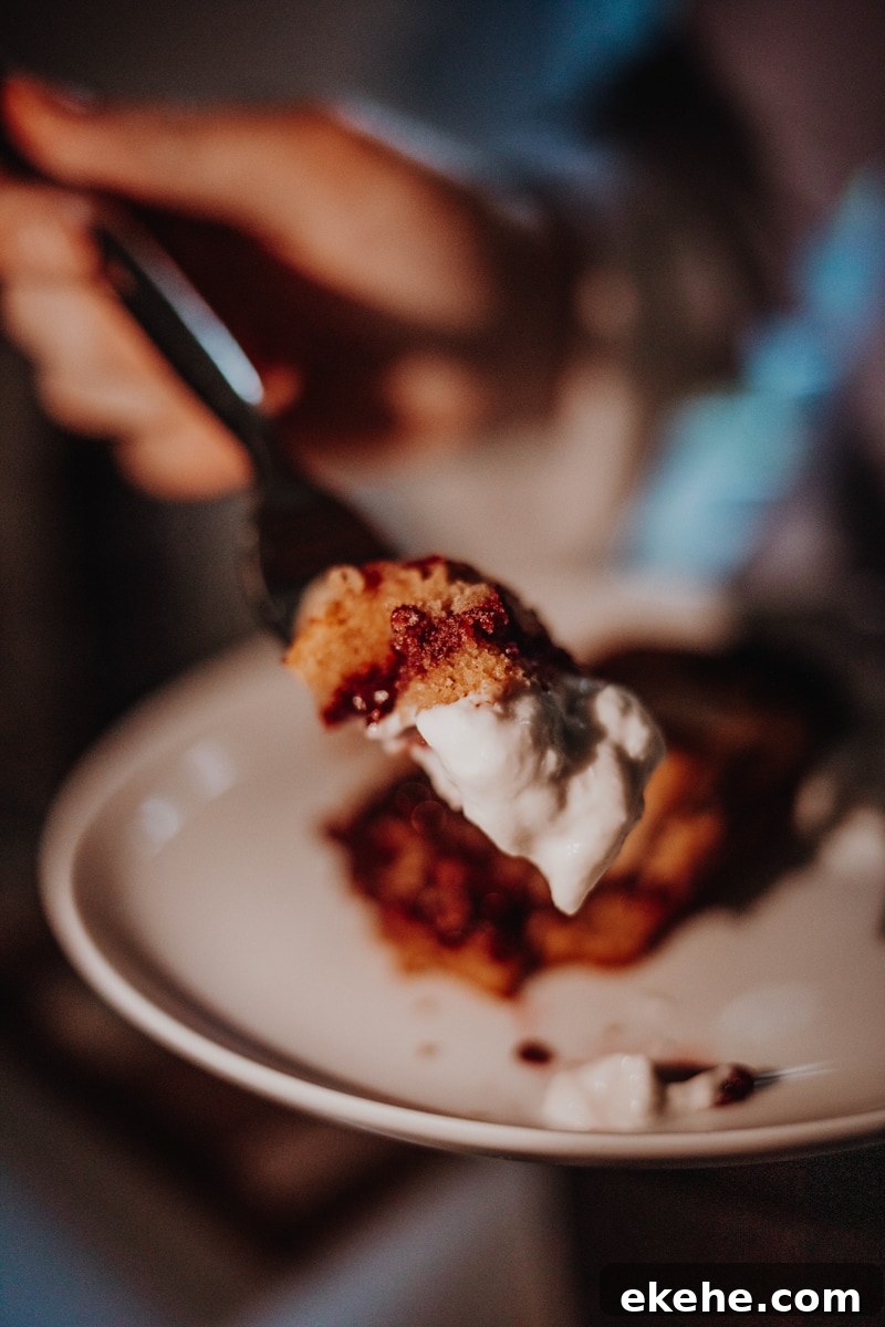 A forkful of blackberry bakewell bar with yoghurt