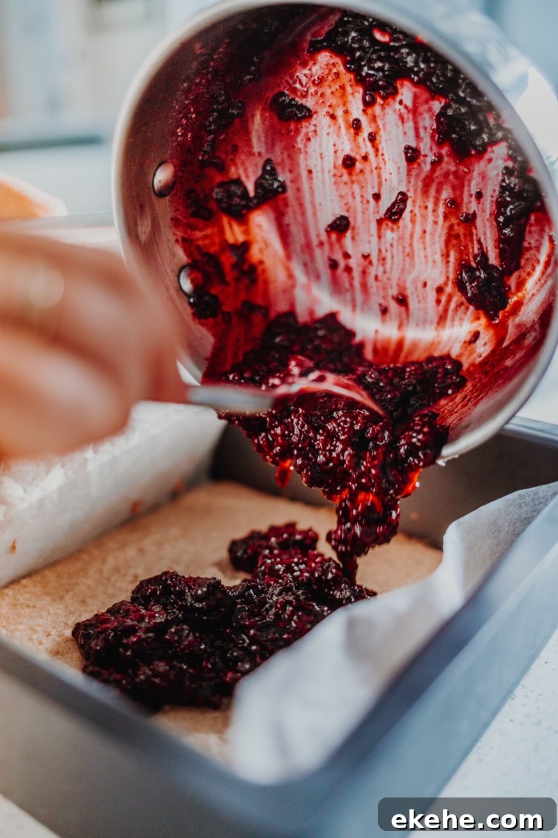 Adding the blackberry chia jam over the partially baked blondie mix