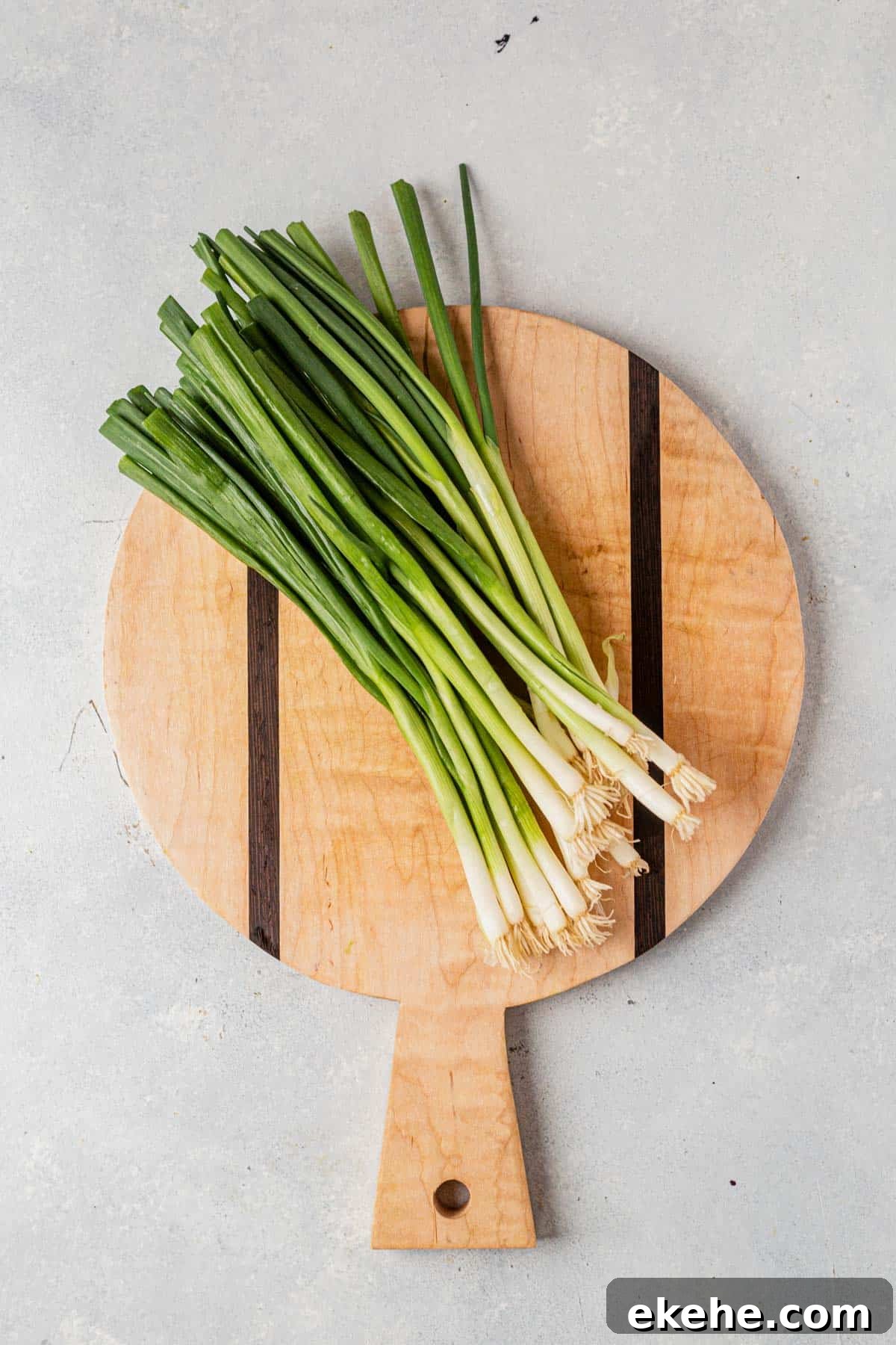 a bunch of green onions on a cutting board