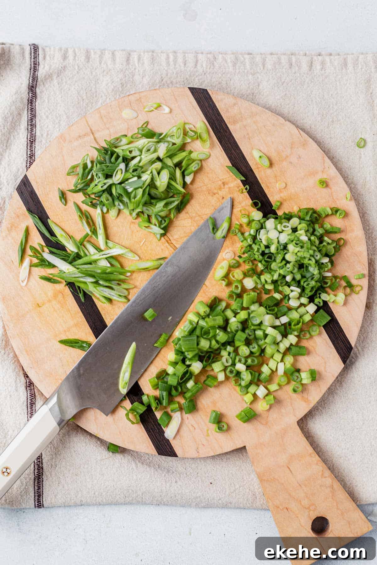 slice green onions on a cutting board with a knife