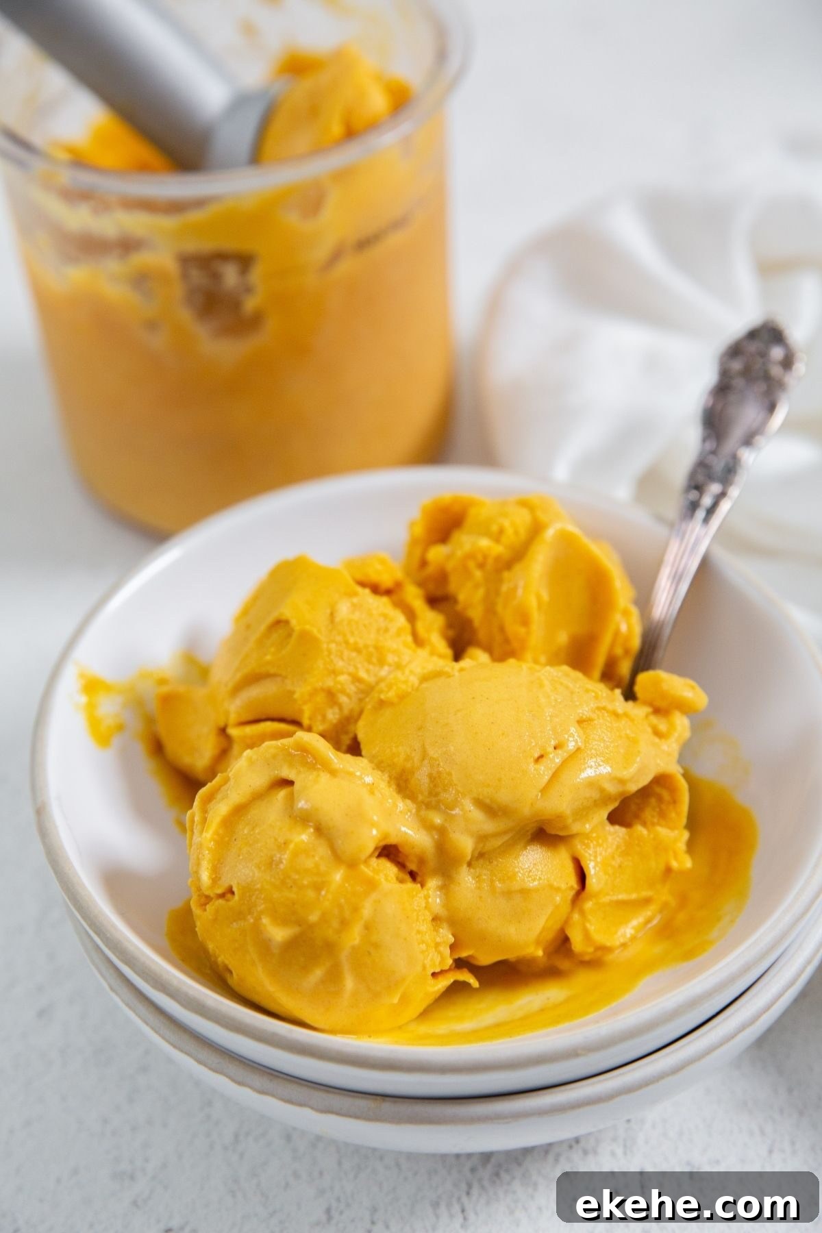 Ninja Creami Pumpkin Ice Cream in a bowl with a spoon in it and a white napkin on the side