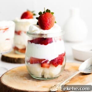 strawberry, angel food cake, and whipped cream trifle in small glass jar