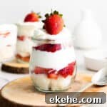 strawberry, angel food cake, and whipped cream trifle in small glass jar