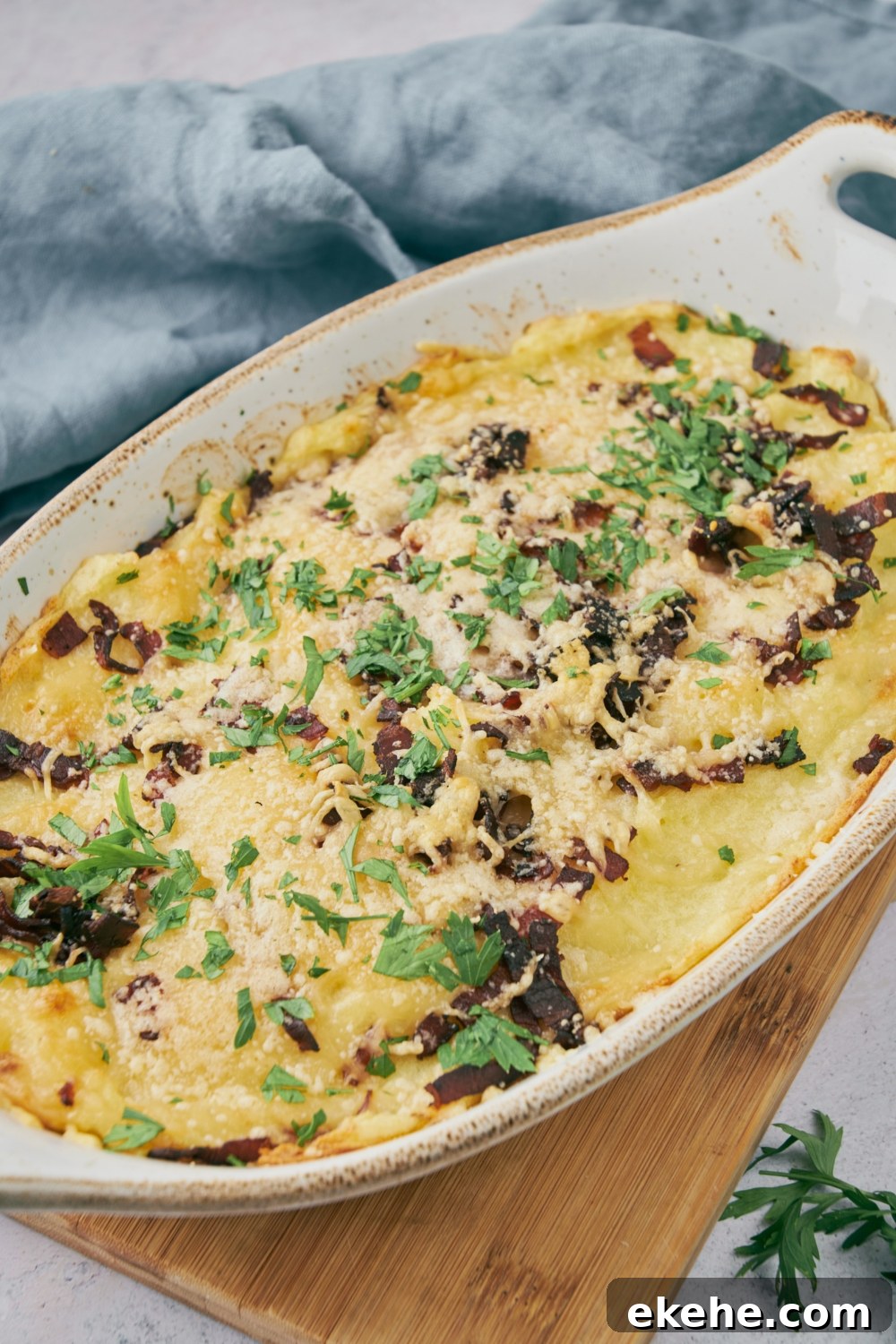 Finished meatloaf casserole in a white serving dish with green garnish