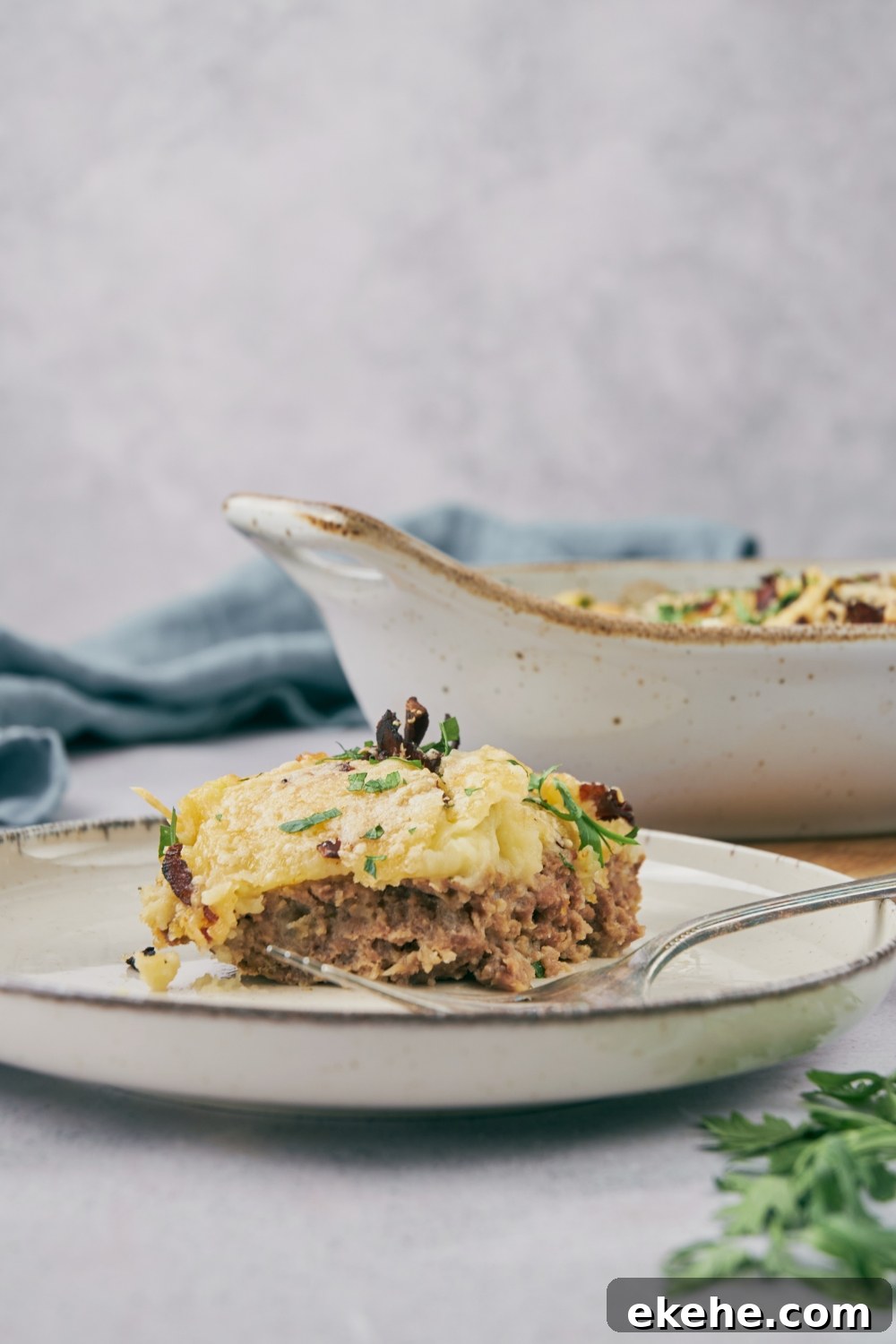 A slice of loaded meatloaf casserole on a white plate.