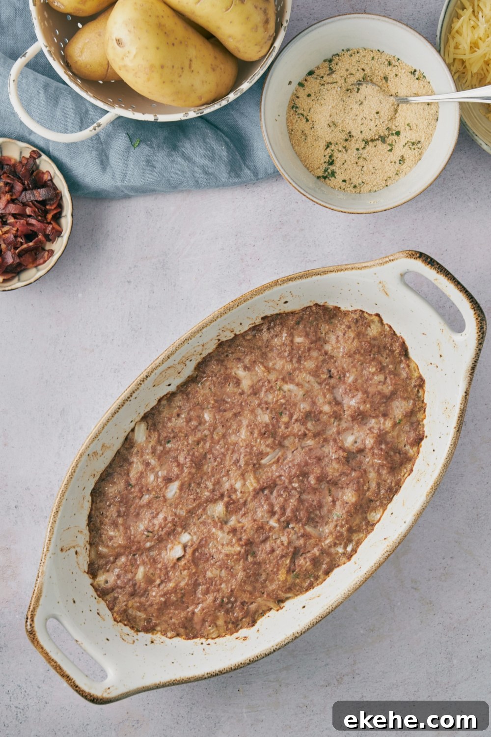 Brown meat mixture in a white casserole dish.
