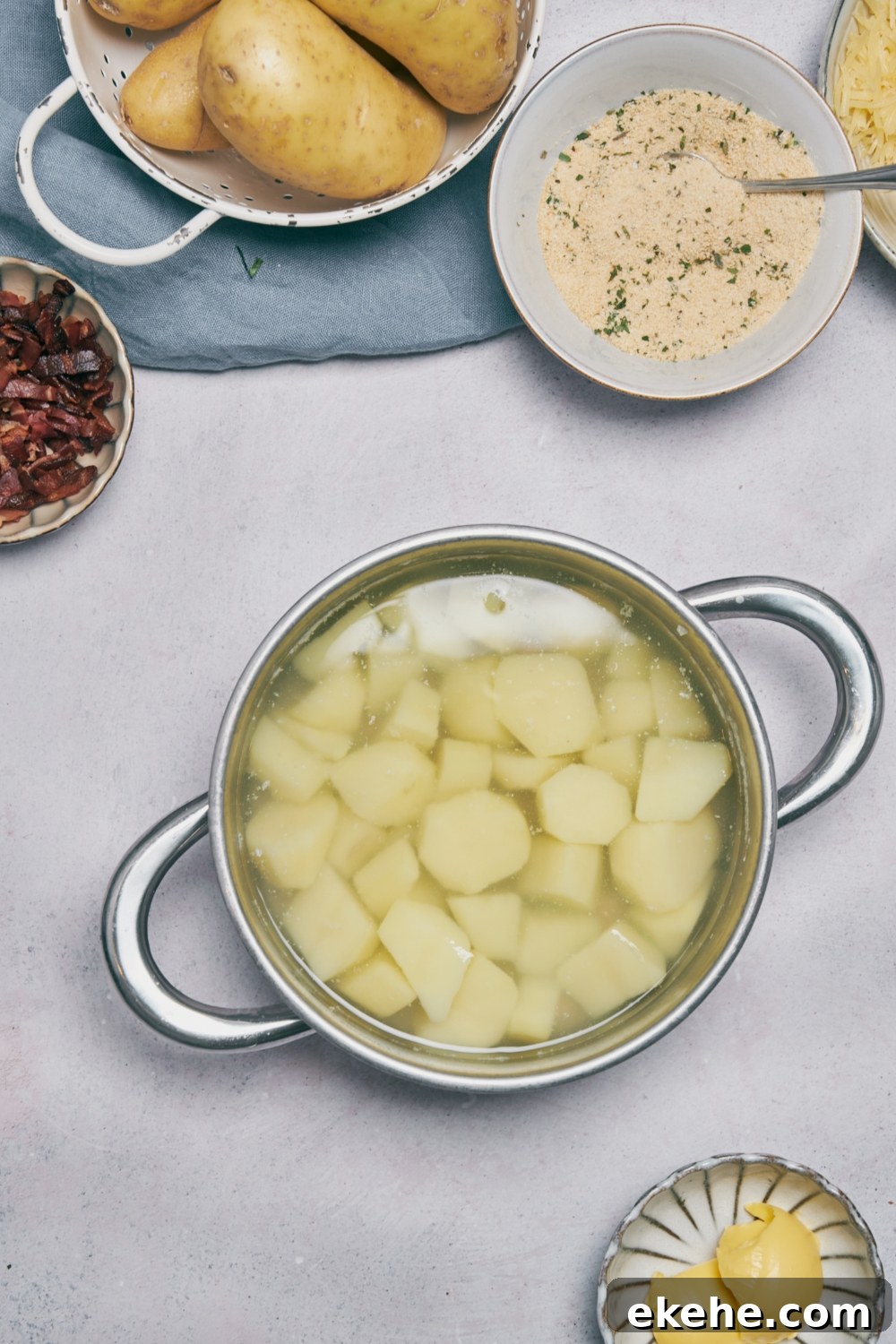 Potato pieces in water in a silver cooking pot