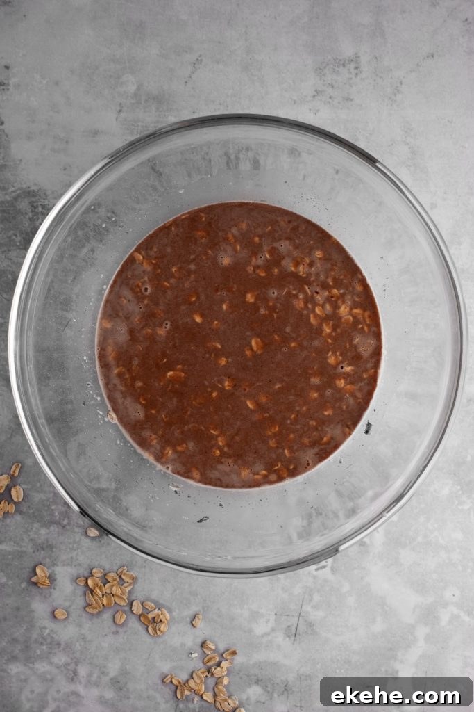 Overhead view of the ingredients mixed together in a glass bowl, on a grey marble table.