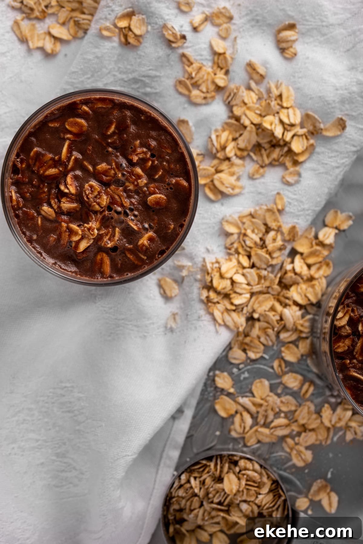Overhead photo of Nutella oats on a white linen, with rolled oats scattered on the table.