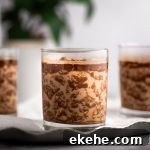 Three glasses of Nutella overnight oats on a metal tray on a white background.