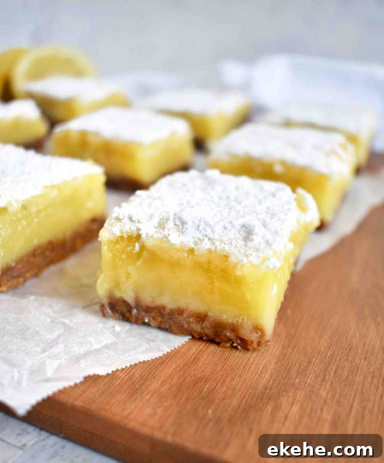 lemon bars in a row on a wooden platter