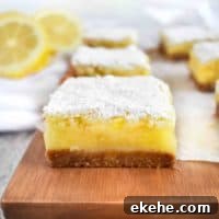 lemon bar on wooden board with lemons in back