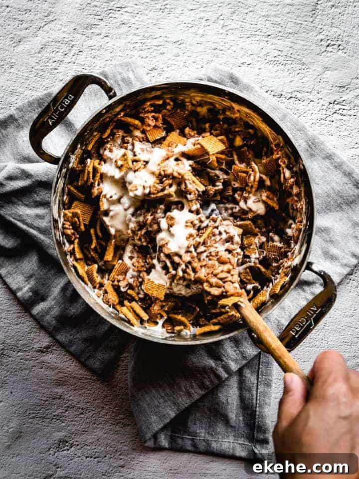 mixing melted marshmallows and cereal in a pot to make S'mores Rice Krispie treats