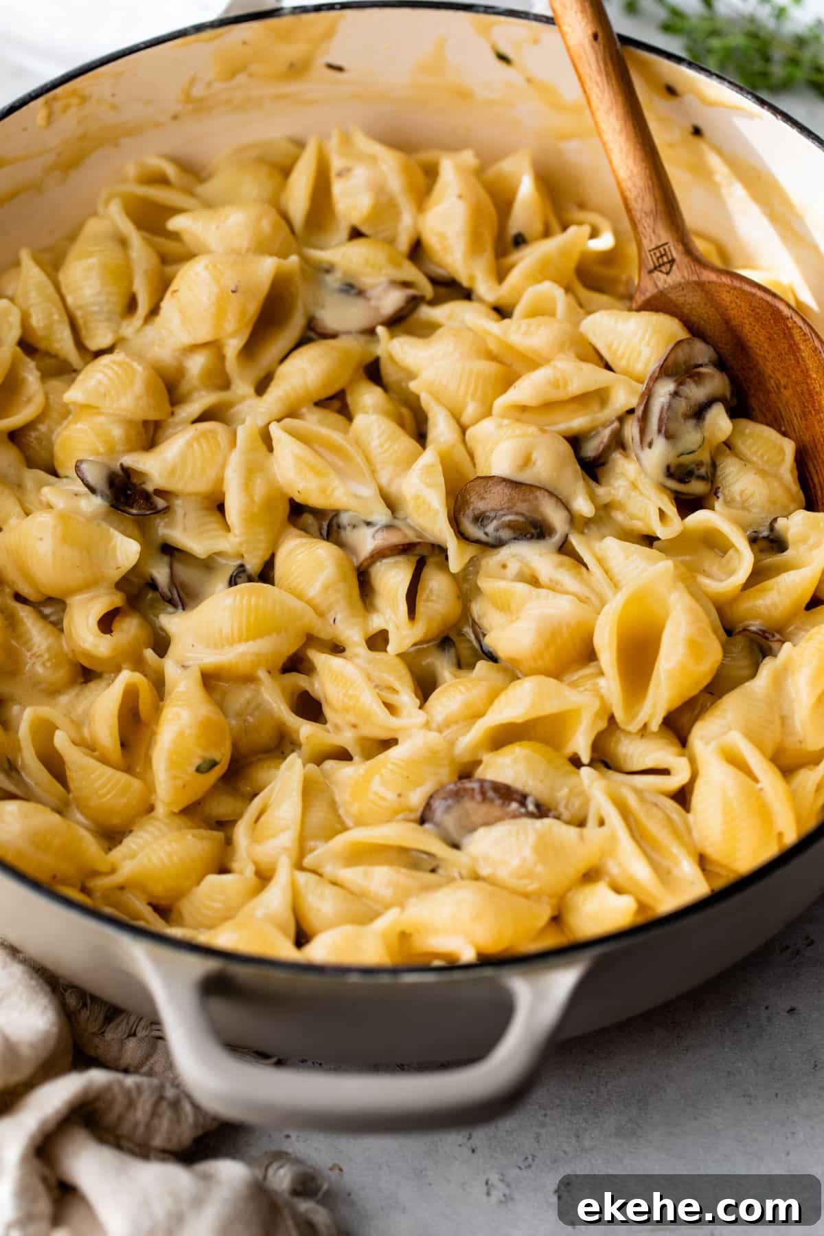 truffle mac and cheese in a dutch oven with a wooden spoon