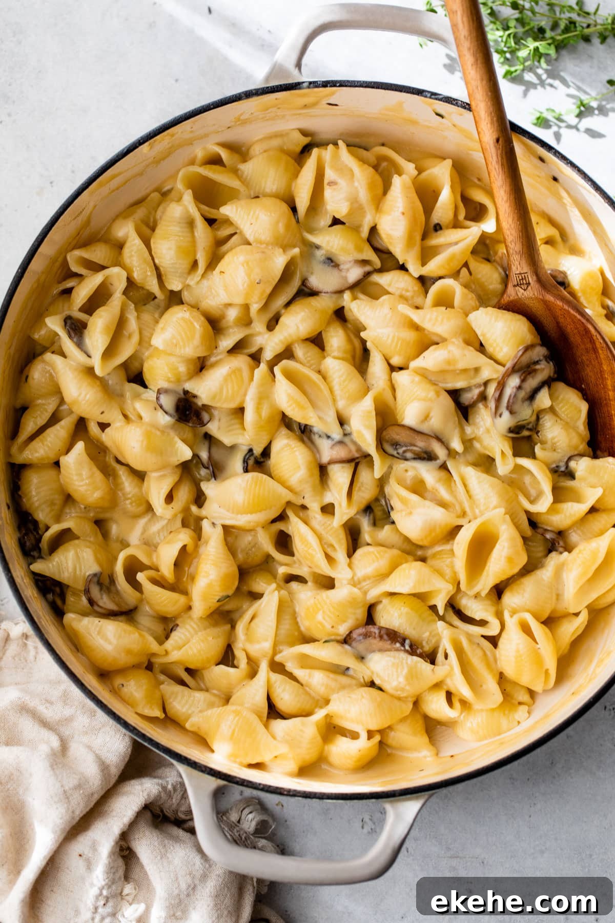 overview of truffle mac and cheese in a dutch oven with a wooden spoon