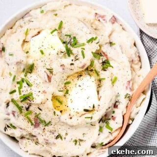 red skin mashed potatoes in bowl with wooden spoon on the side.