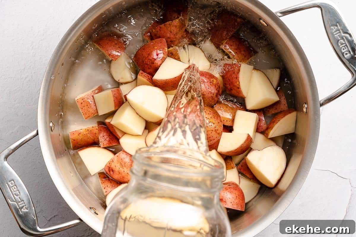 water being poured into pot with potato chunks