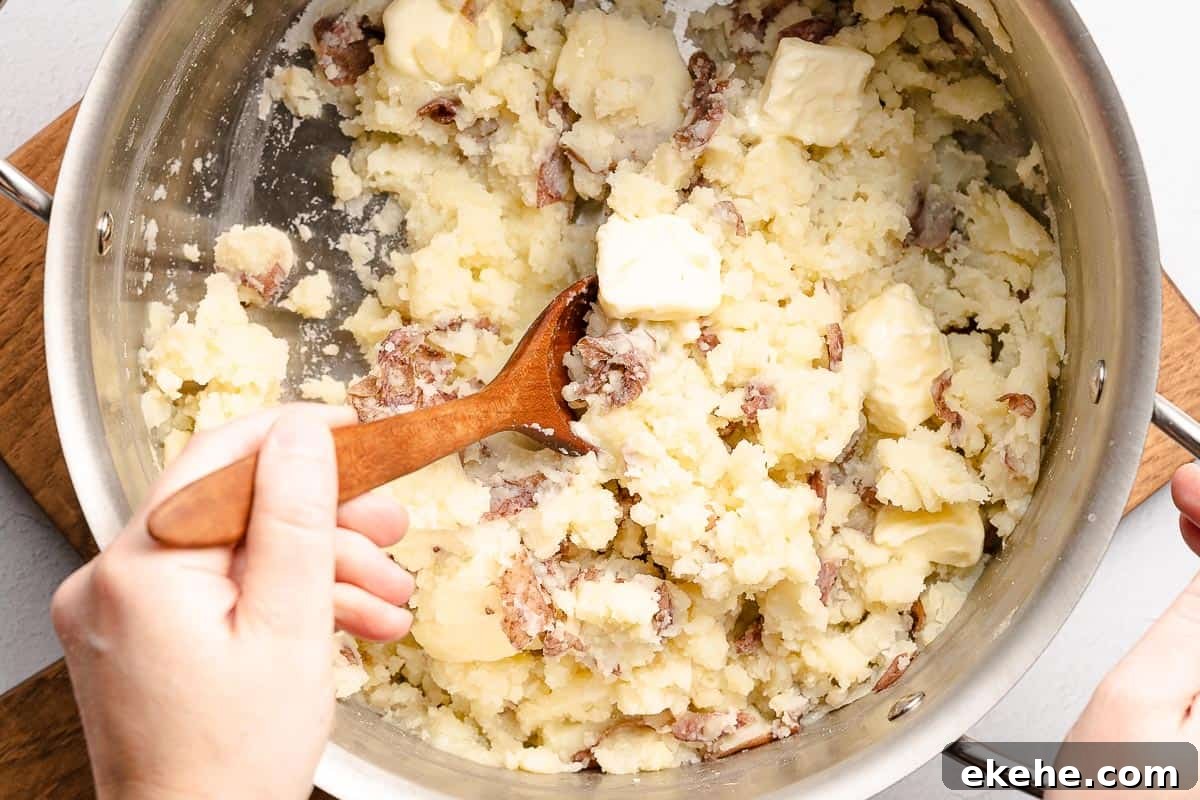 pats of butter being stirred into mashed potatoes