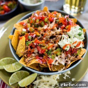 Loaded pulled pork nachos with salsa and avocado crema