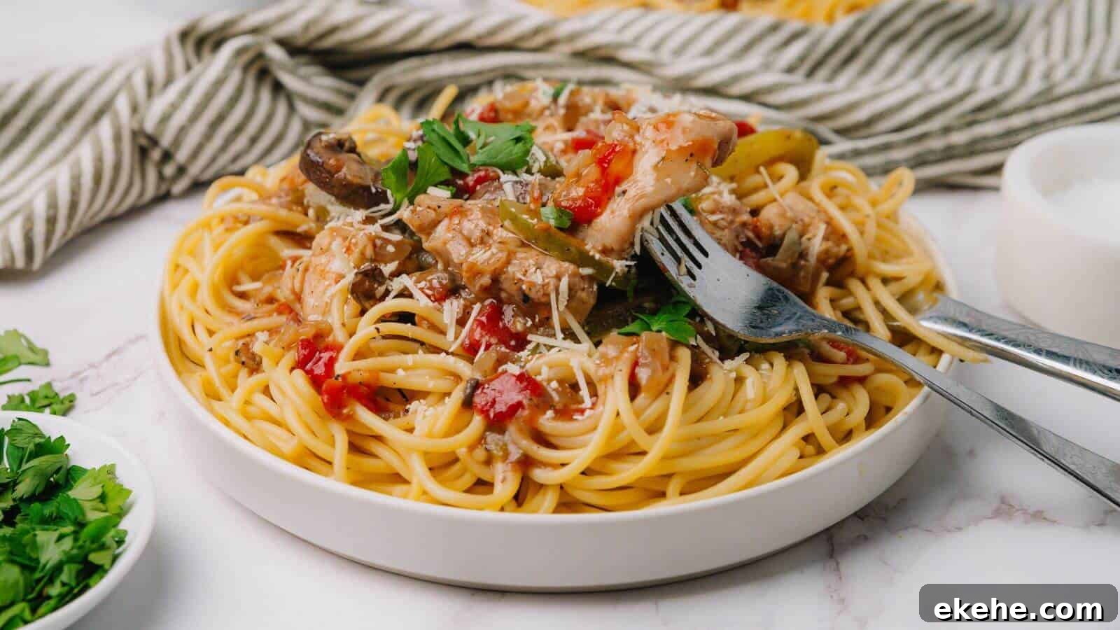Plate of spaghetti topped with tomato sauce, mushrooms, and herbs, with a fork and spoon on the side.