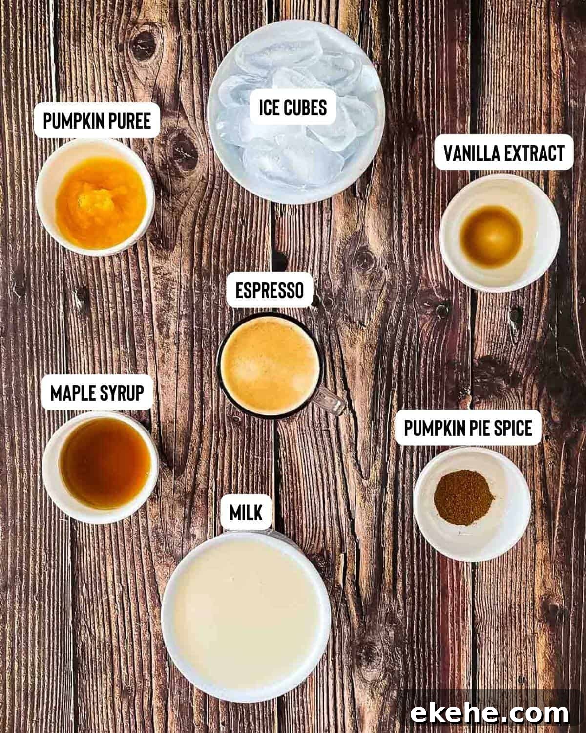 The ingredients for homemade iced pumpkin spice latte measured out and placed on a wooden table.