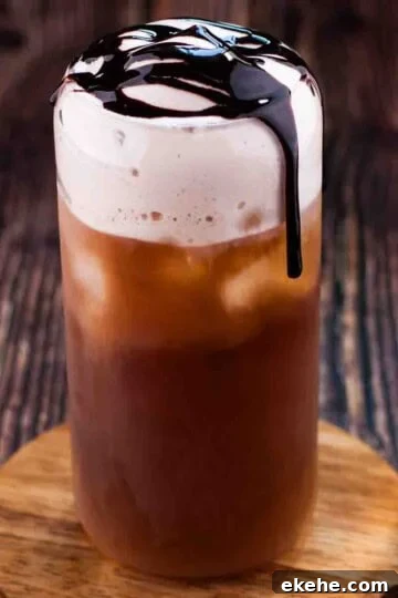 Starbucks copycat chocolate cream cold brew in a tall glass and drizzled with chocolate sauce.