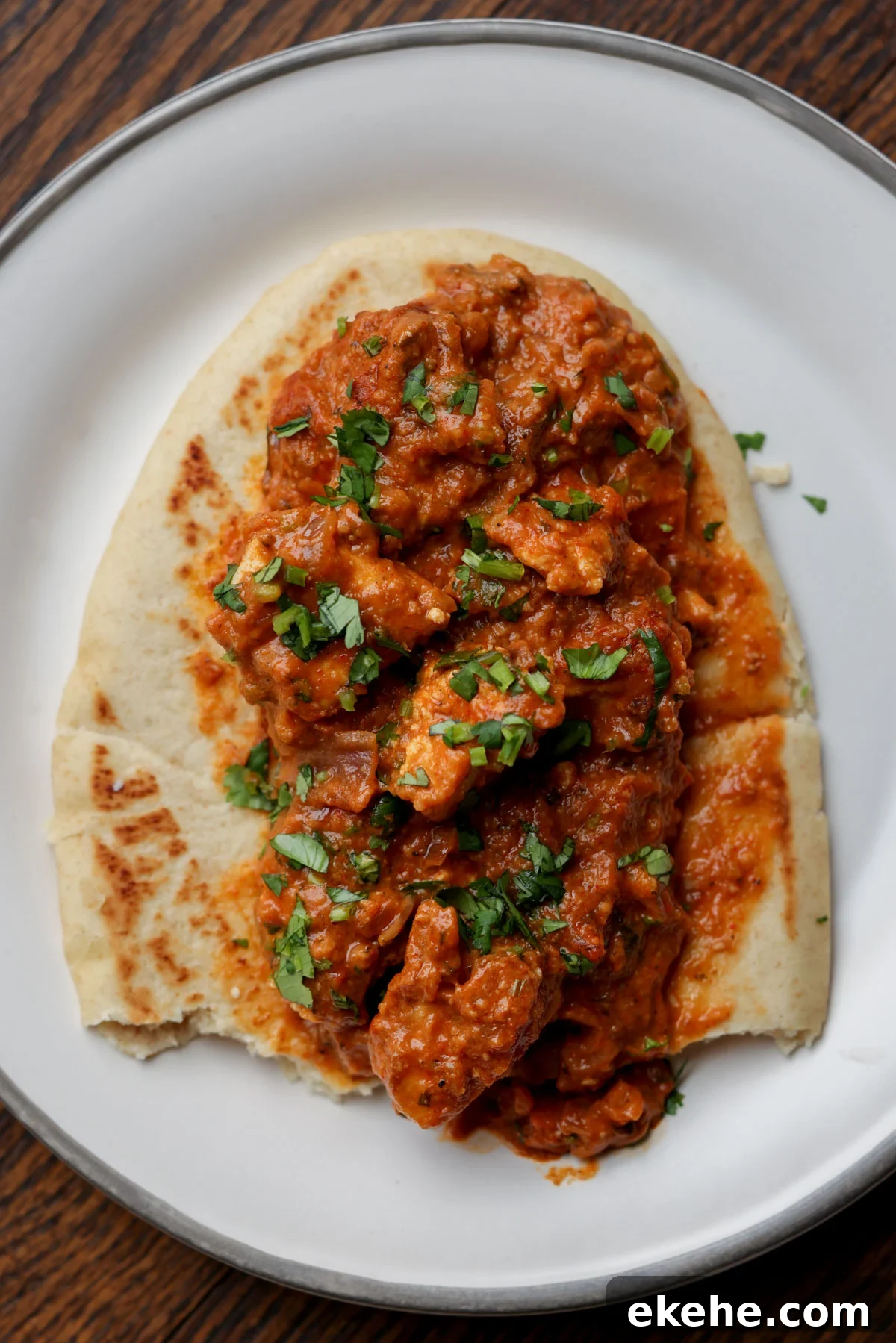 flatbread with chicken angara on top on a plate