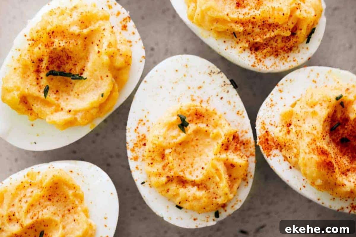 Classic Deviled Eggs dust lightly with paprika and top with extra chopped chives.
