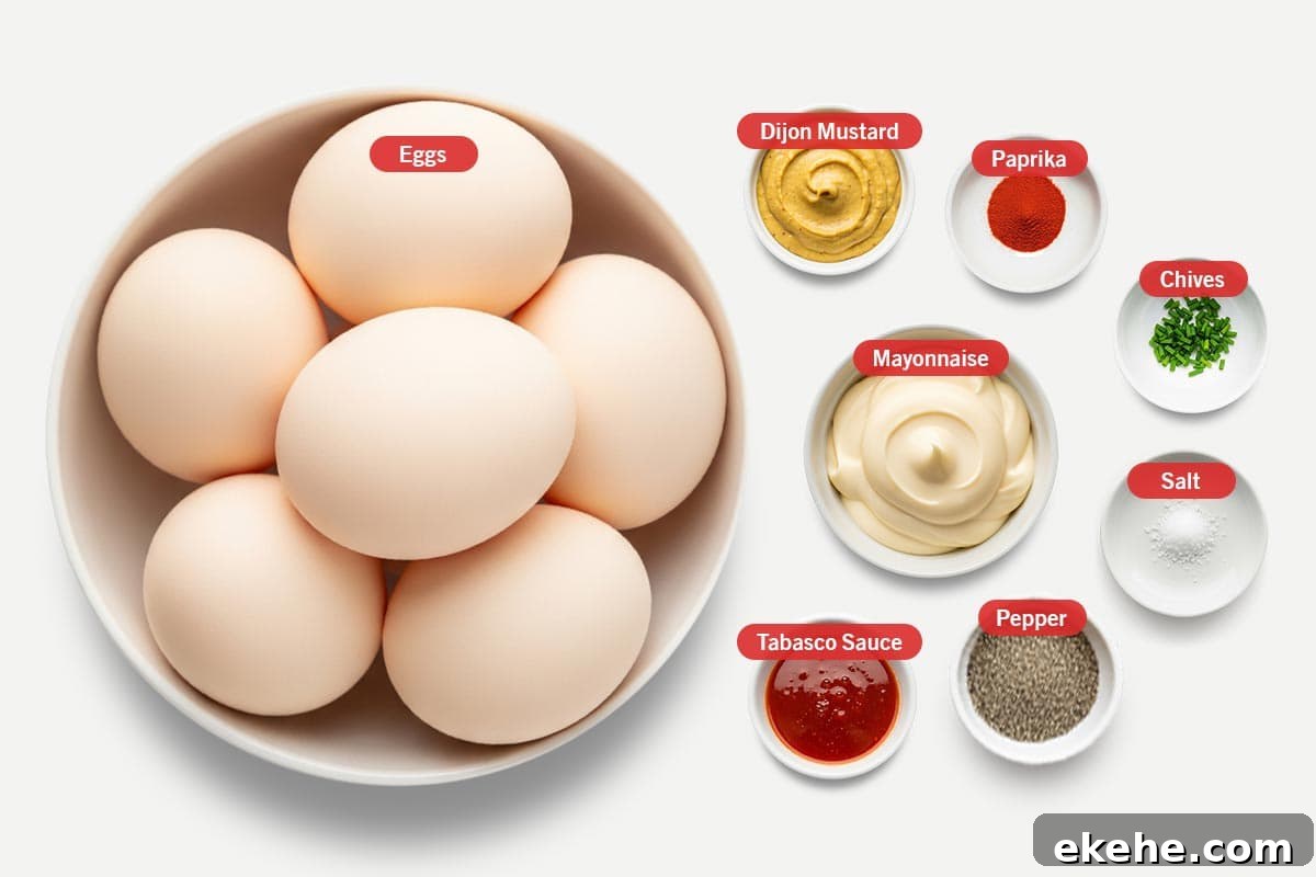 Top shot of ingredients: Eggs, Mayonnaise, Dijon Mustard, Tabasco Sauce, Paprika, Chives, Salt, Pepper.