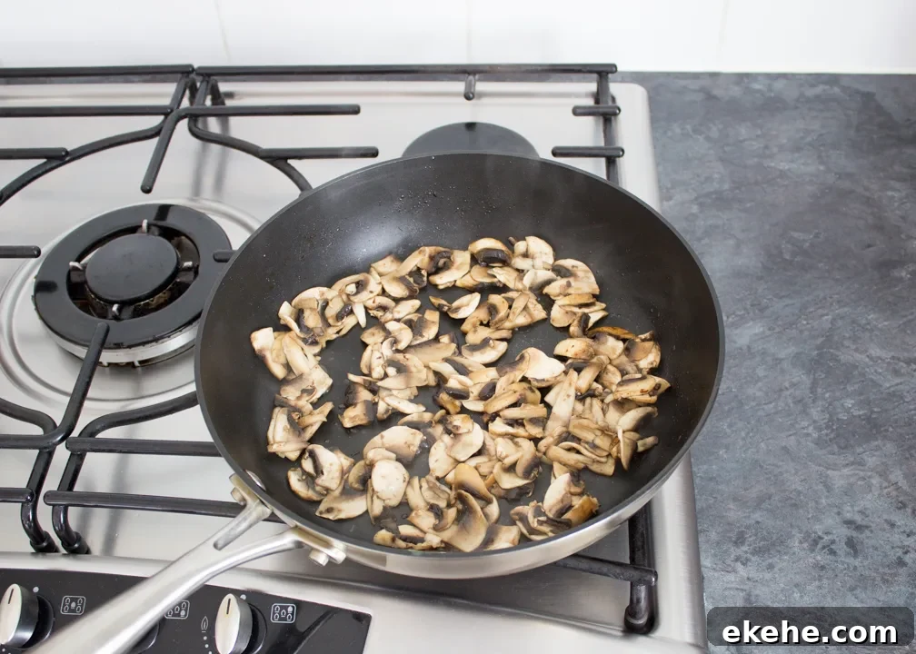 Sliced mushrooms frying in a pan
