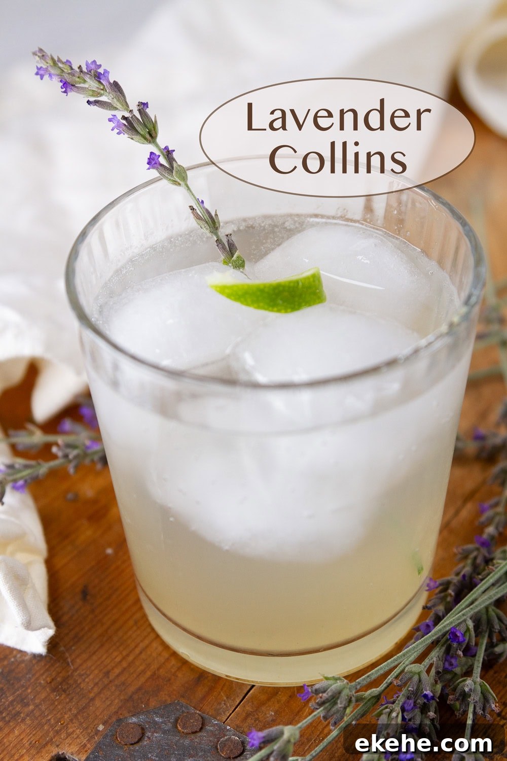 a glass filled with a mocktail and ice and garnished with lime and lavender. 