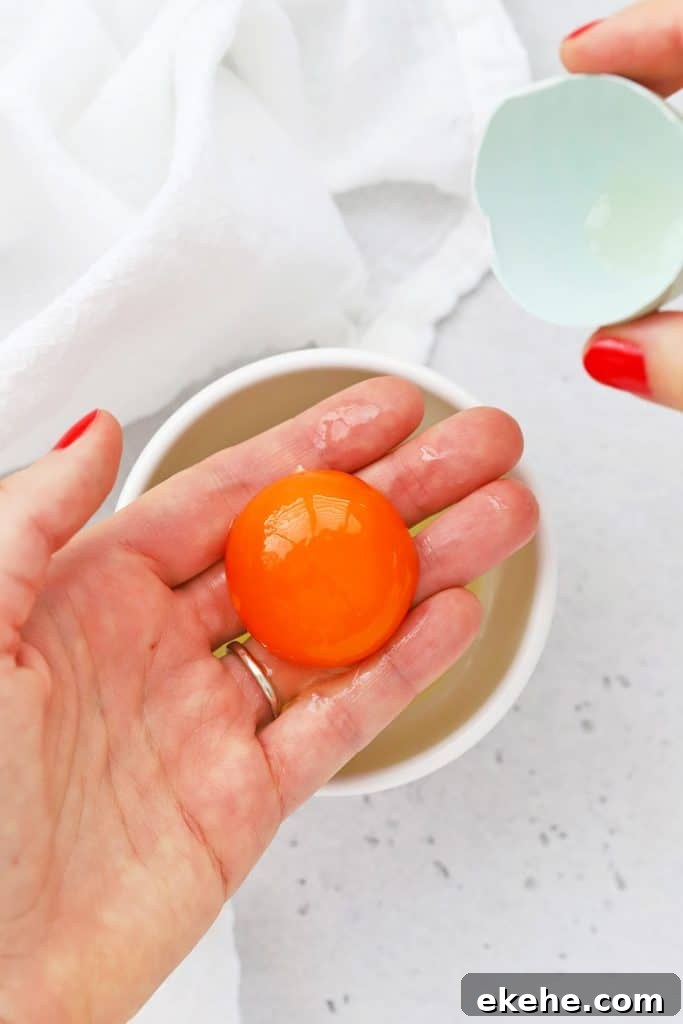 Overhead view of using your hand to separate egg yolks and egg whites