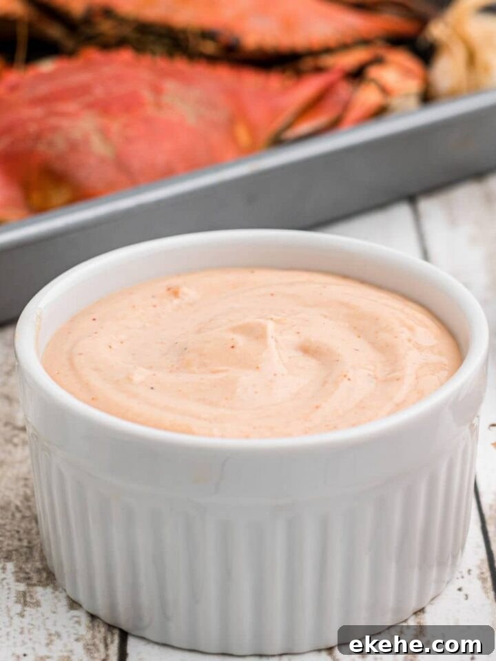 A bowl of seafood sauce with some boiled crabs in the background
