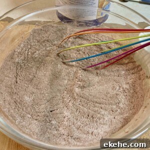 glass bowl with sugar free hot cocoa mix ingredients and whisk