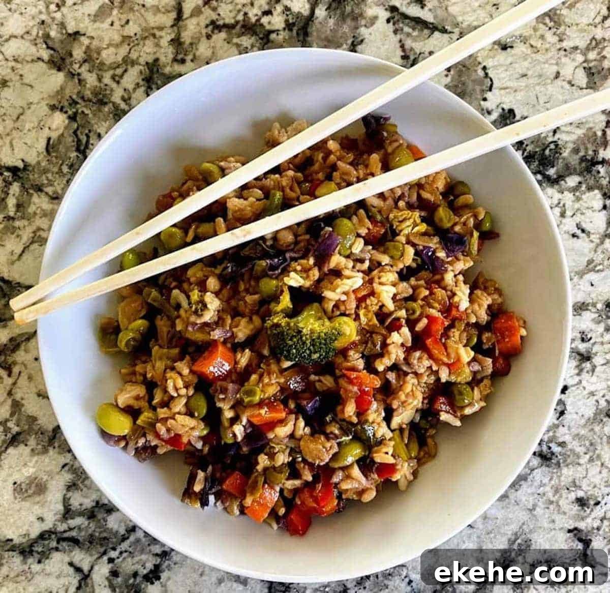 Vegan vegetable fried rice in a bowl with chop sticks.