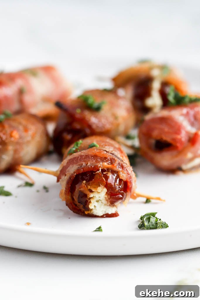 Side angle of bacon wrapped dates on white plate with fresh thyme.