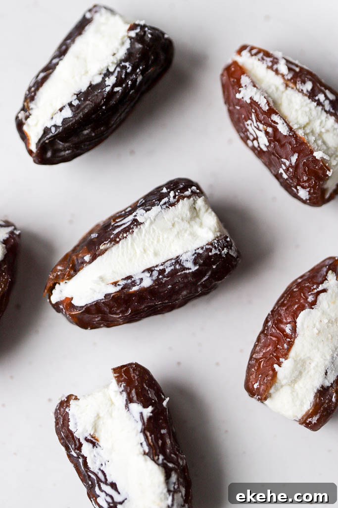 Top down view of cheese stuffed in dates on white plate.
