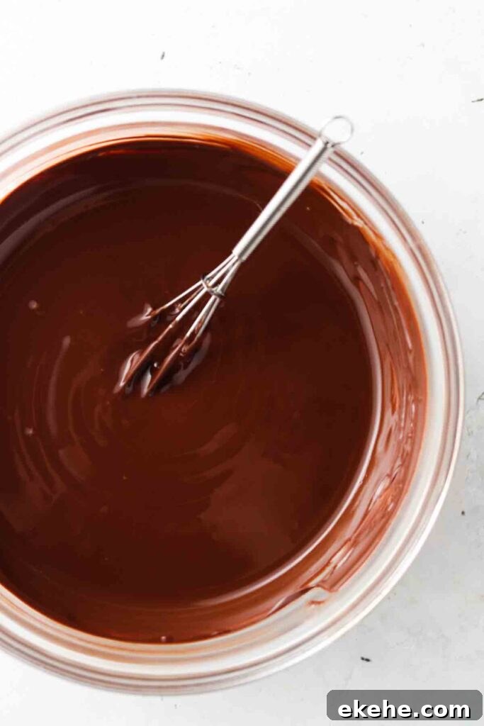 melted chocolate in a bowl with a whisk