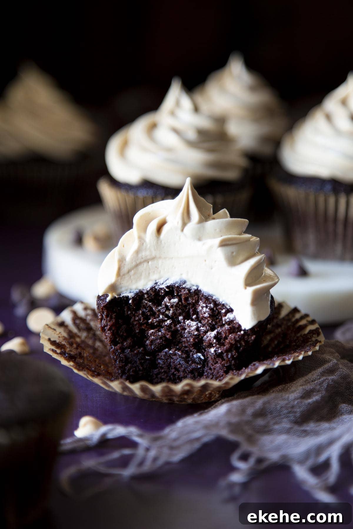 A chocolate cupcake with peanut butter frosting, with a bite taken out of it