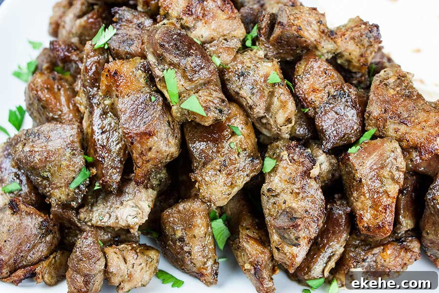 Closeup of the crispy pork carnitas on a white plate garnish with chopped cilantro.