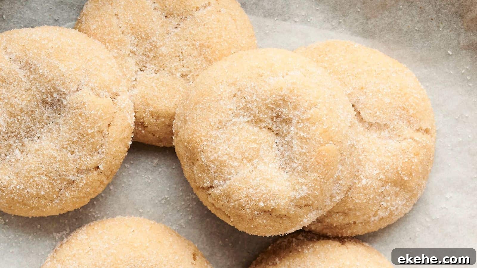 Close-up of six sugar-coated cookies on parchment paper.