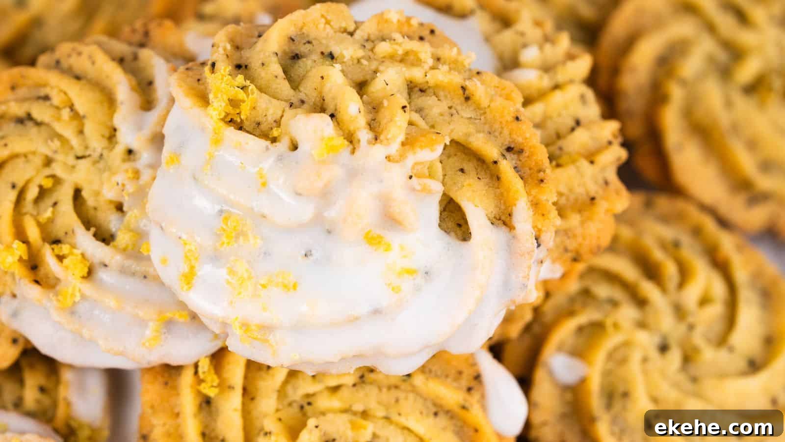 Close-up of spiral lemon poppy seed cookies drizzled with white icing and garnished with lemon zest.