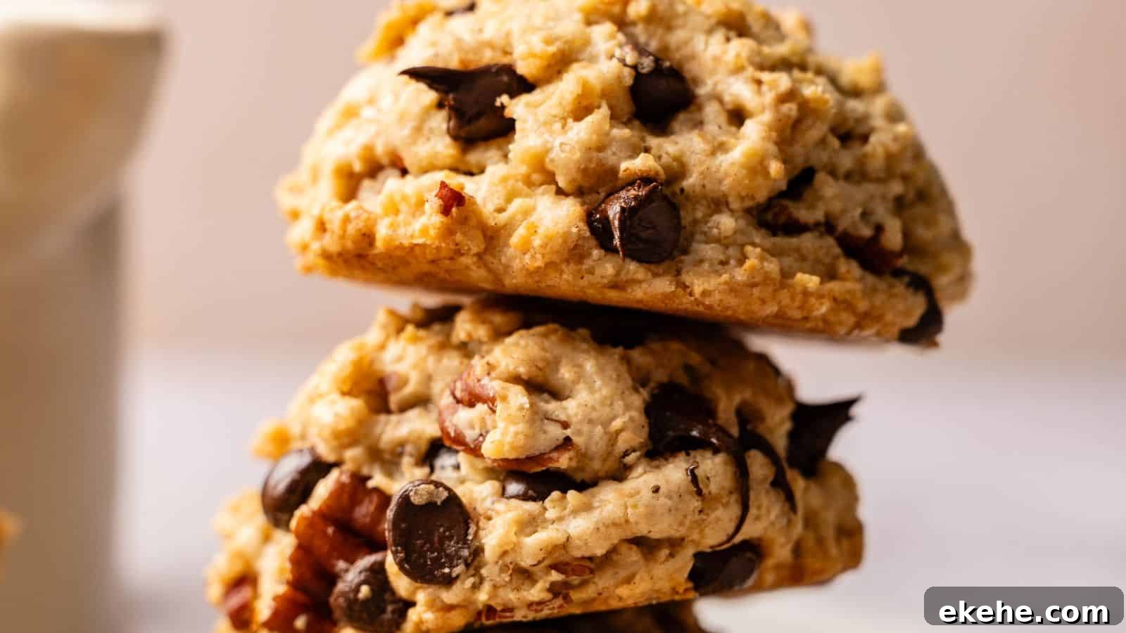 Two chocolate chip cookies with nuts stacked on top of each other in close-up view.