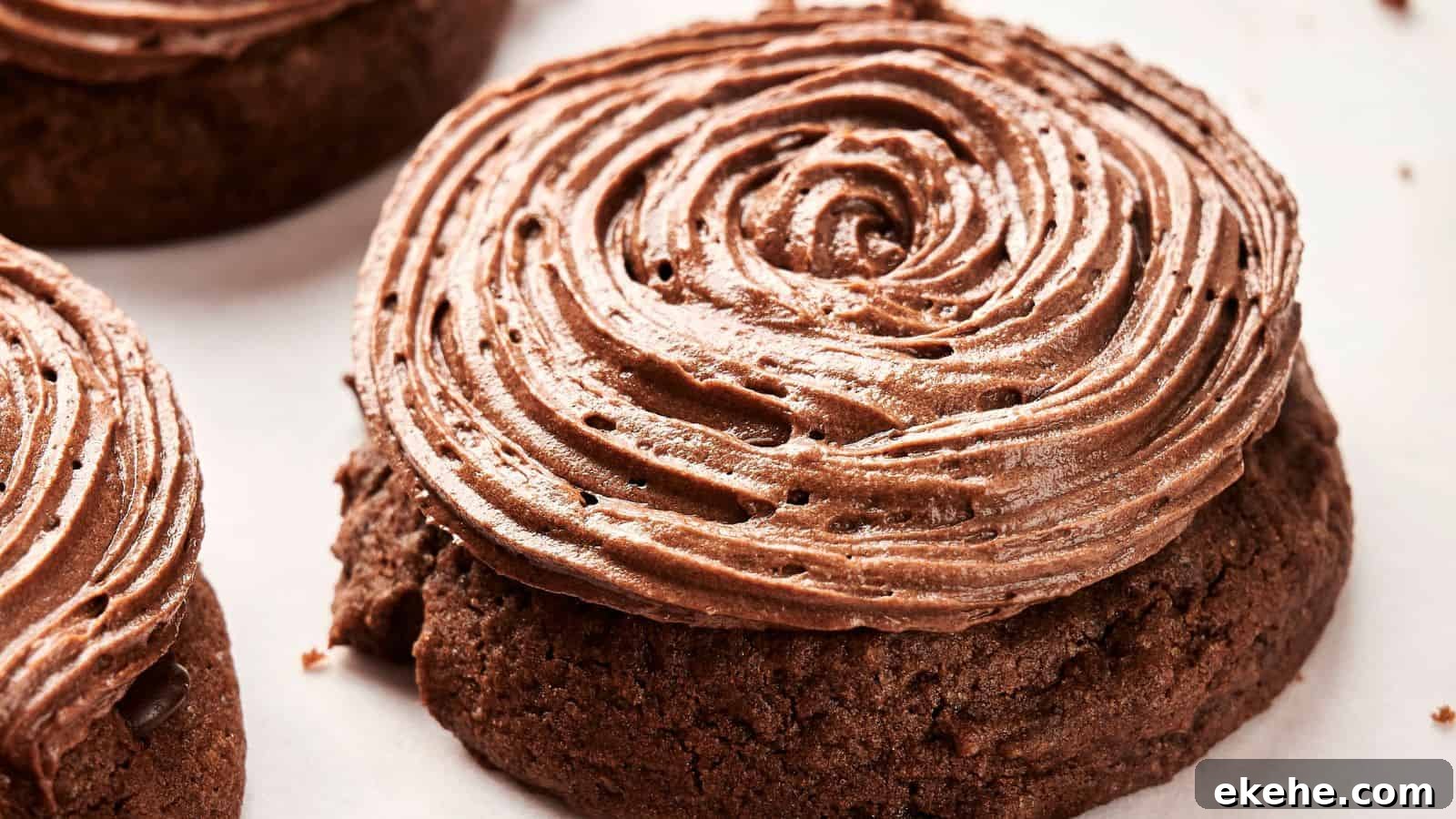 A delectable close-up of a Copycat Crumbl Chocolate Cake Cookie, crowned with a swirl of rich chocolate frosting, resting on a pristine white surface.