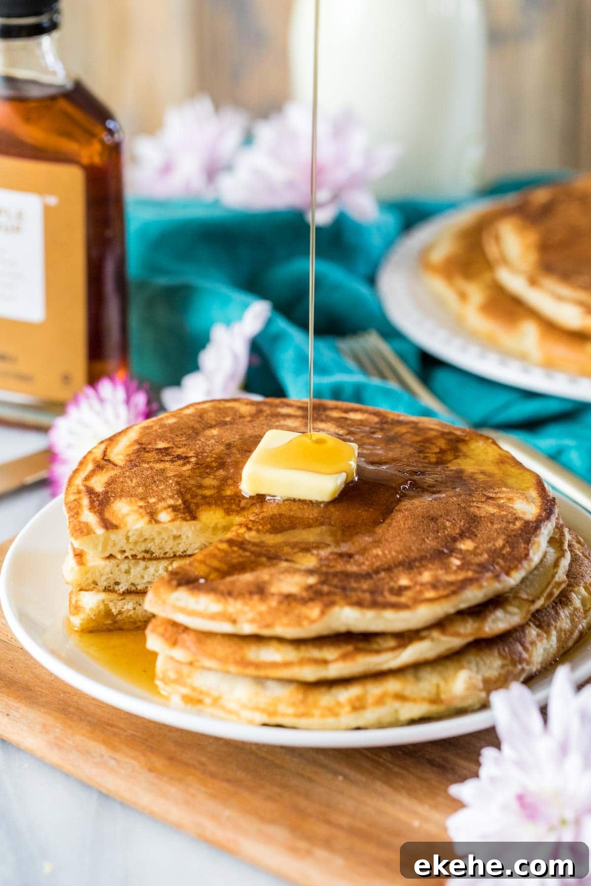 Fluffy Sourdough Pancakes Recipe for Crispy-Edge Breakfast 2 Syrup being poured over a buttered stack of sourdough pancakes.