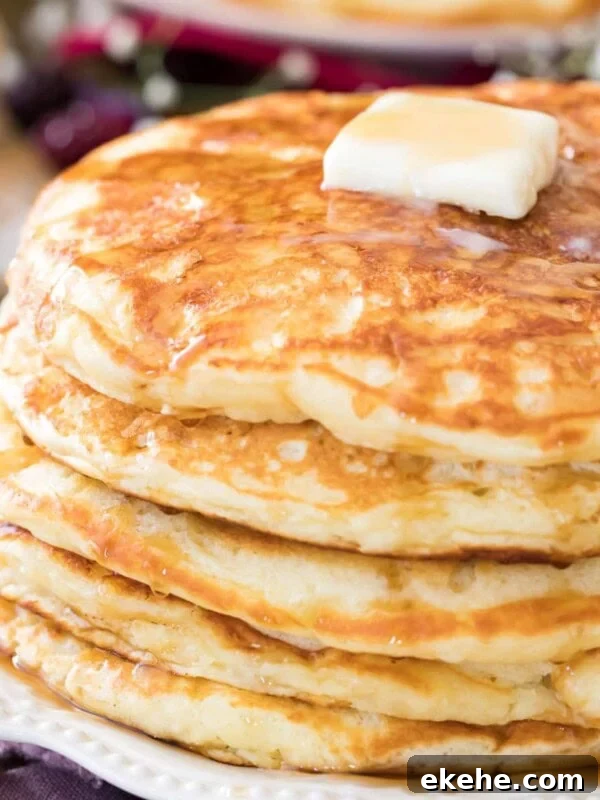 Fluffy Sourdough Pancakes Recipe for Crispy-Edge Breakfast 9 buttermilk pancakes on white plate with butter
