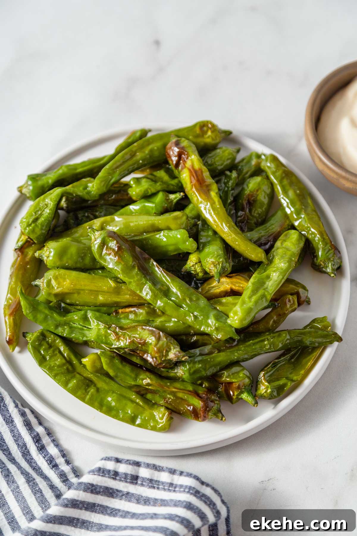 air fryer shishito peppers on a plate.
